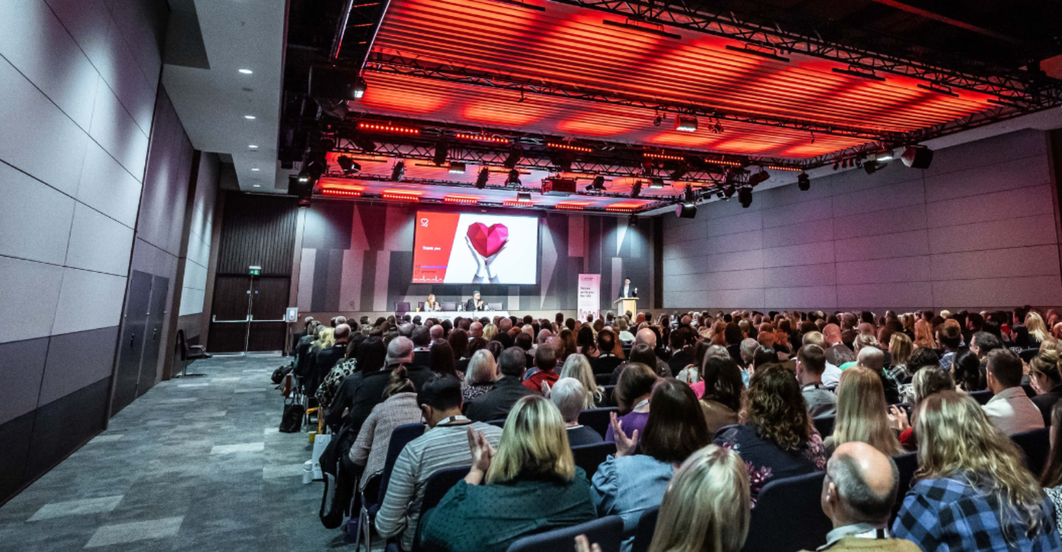 an auditorium full of people watching a presentation