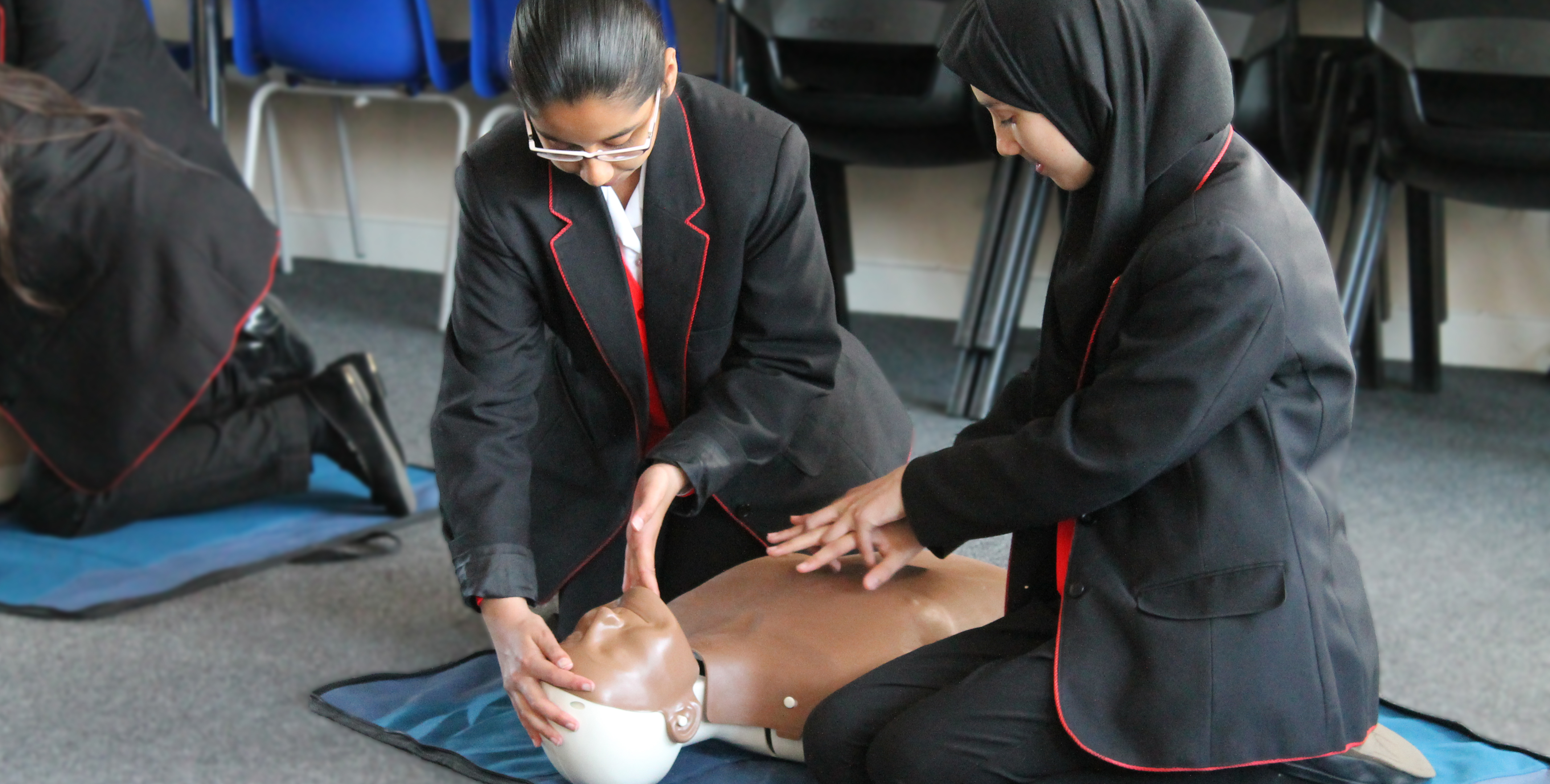 School children giving CPR to a mannikin 