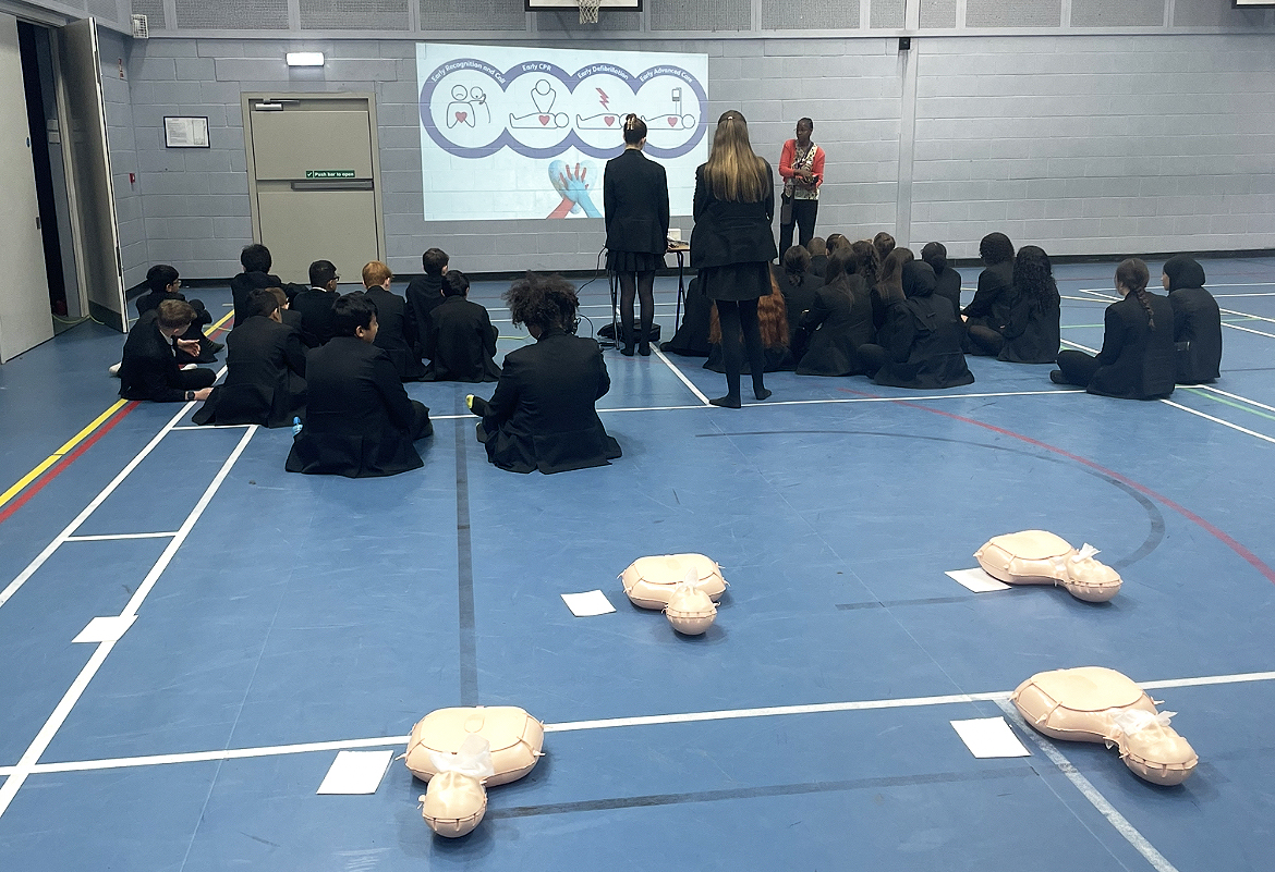 School children giving CPR to a mannikin 