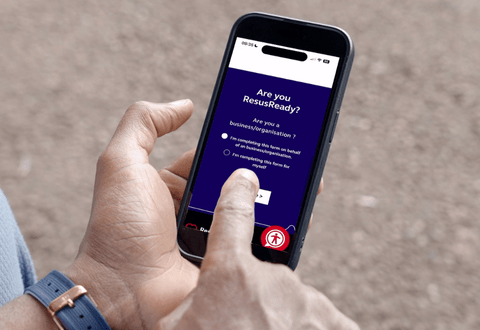 Person holding a smartphone with the screen display reading "Are you ResusReady?"