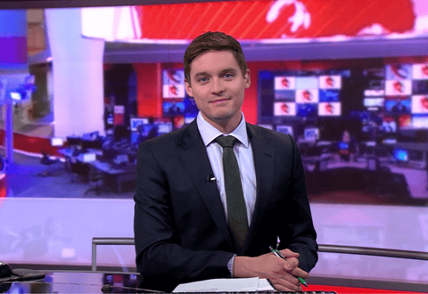 BBC news presenter Rich Prestion smiling at new desk