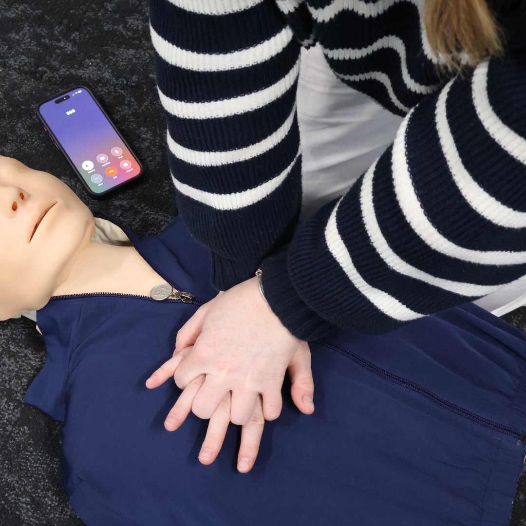 person practicing chest compressions on a training manikin