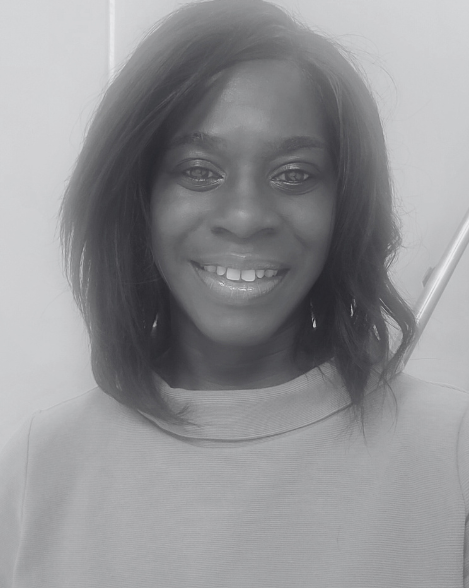 An image of Esther Kuku smiling in an office. 