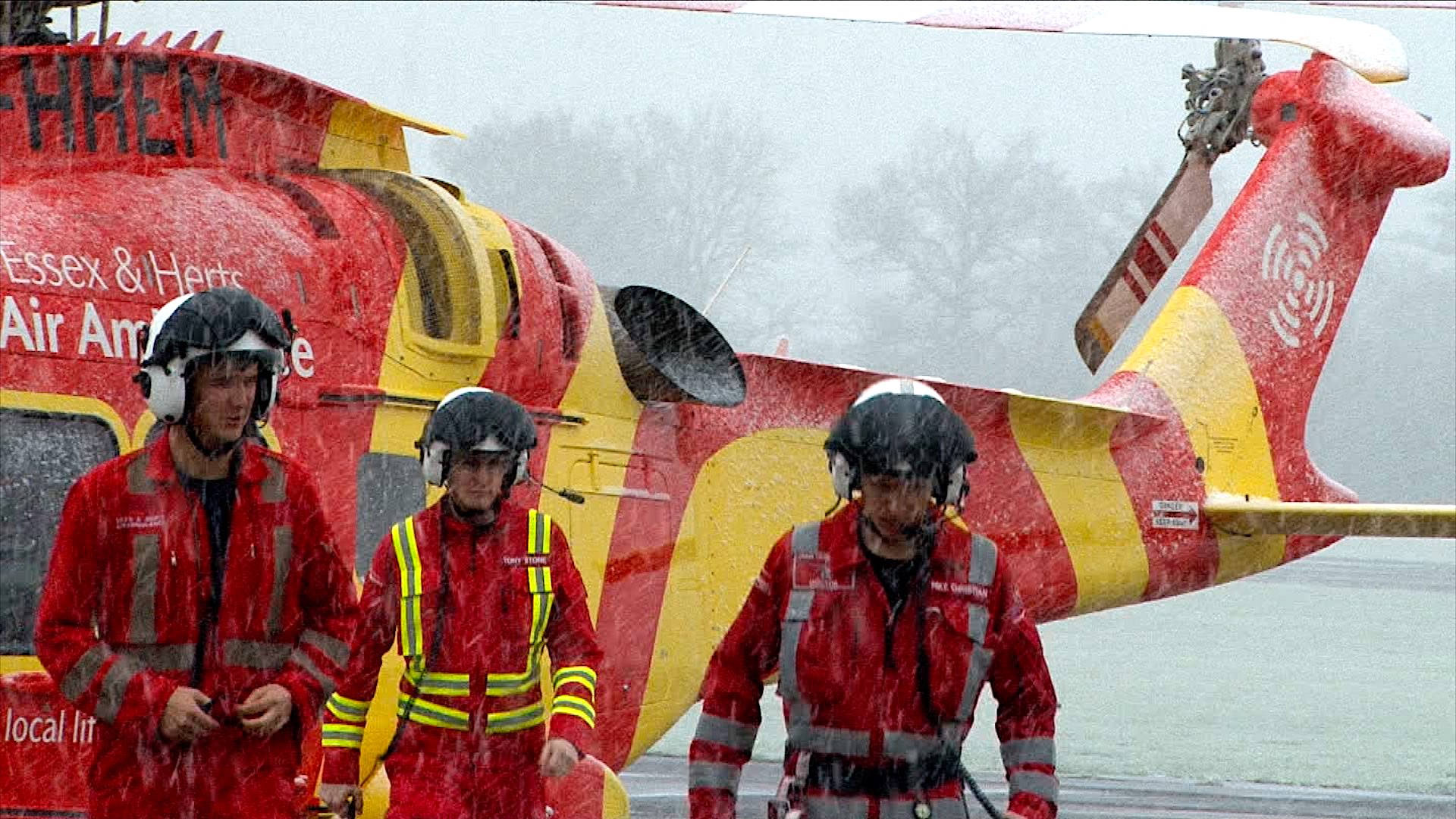 3 men walking from a Helicopter in the rain