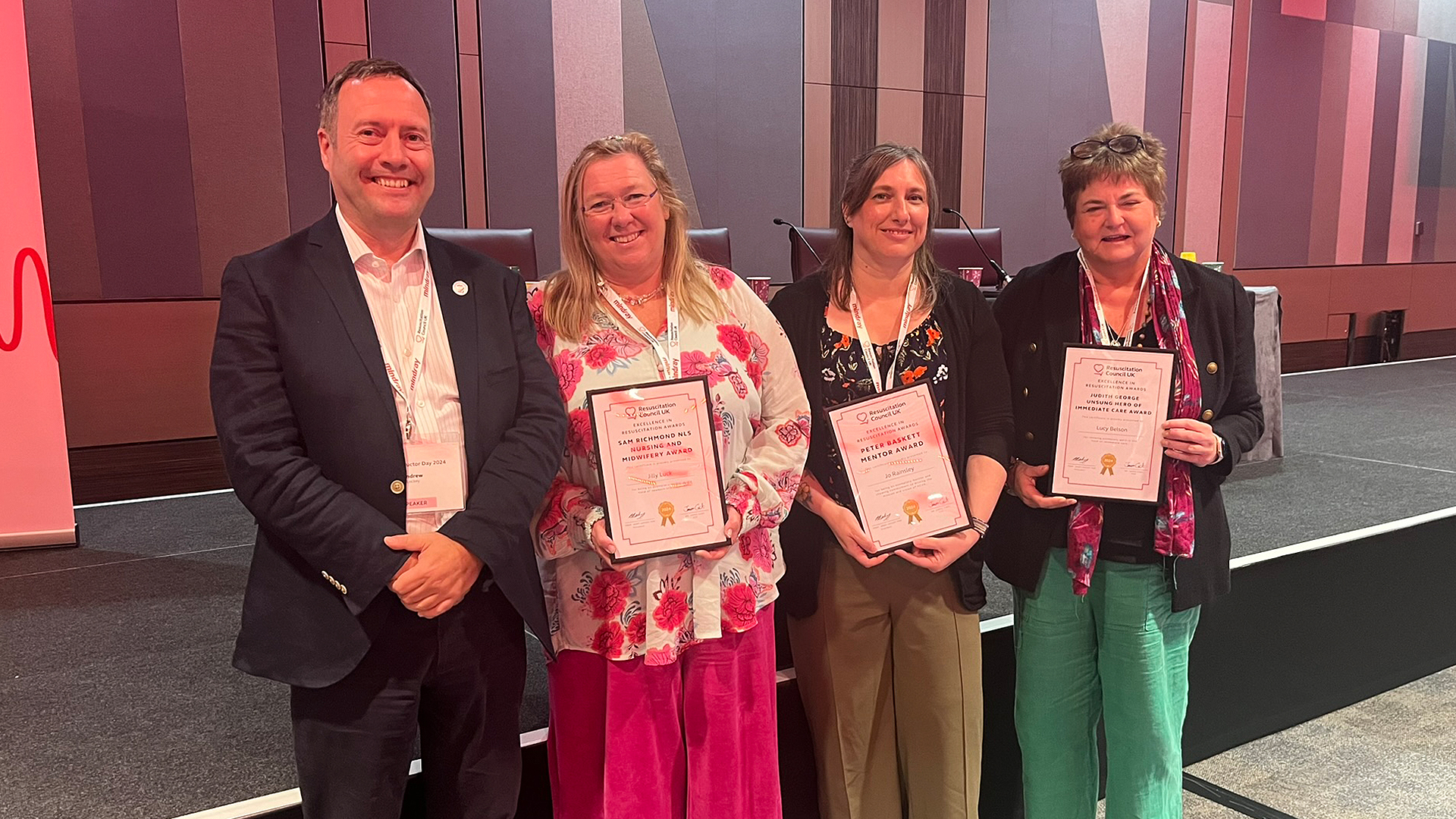 The three winners of the inaugural Excellence in Resuscitation Awards holding their awards and smiling with RCUK Vice President, Andy Lockey.