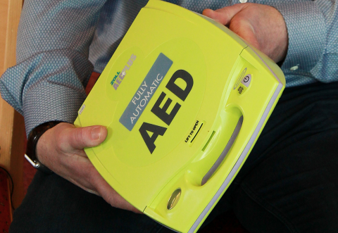 Survivor Paul holds the defibrillator that saved his life