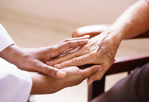 Carer holding hands of patient