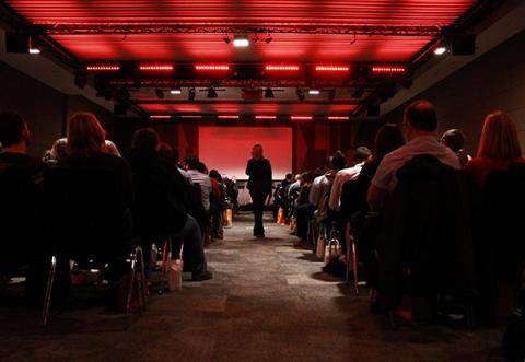 A picture of attendees watching a lecture at a conference