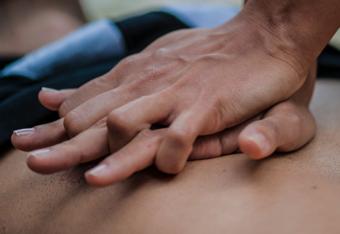 A close up of someone pushing on someone else's chest