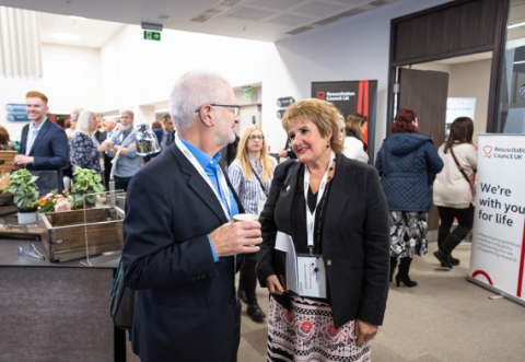 A man and a woman in conversation at a conference