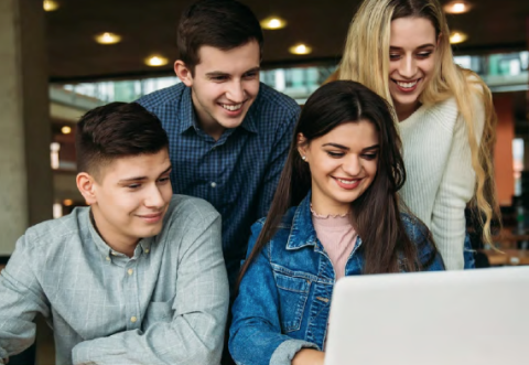 4 diverse individuals looking at a computer screen