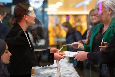 Two ladies handing badges to two other ladies