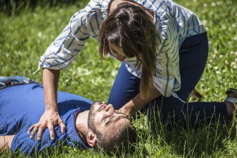 Woman checking on an unconscious man