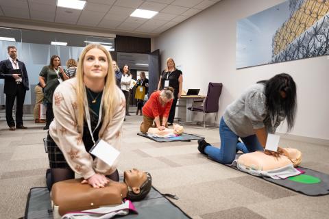 Two young women giving CPR to manikins at RCUK conference