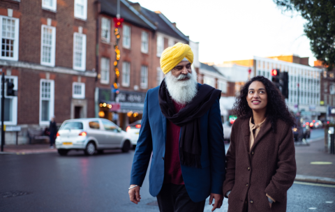 One man and one woman walking down a city street. 