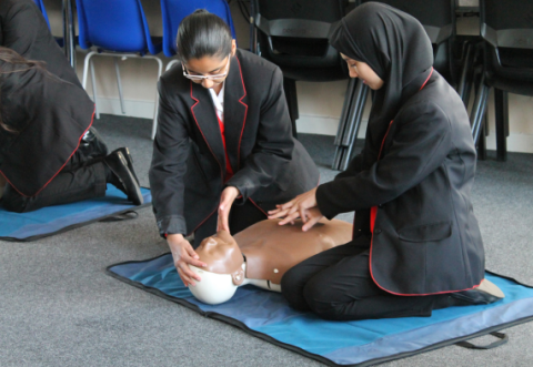 Two school children practicing CPR 