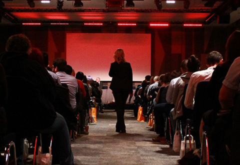 woman walking through the crowd at a conference