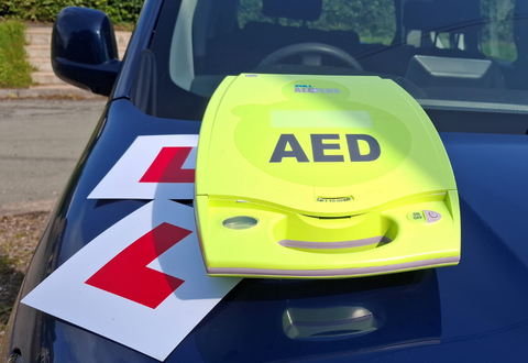 An AED and 'learner' platers sitting on a car bonnet