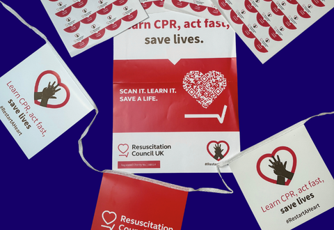 Flatlay of Restart a Heart poster, bunting, and stickers against a dark blue background