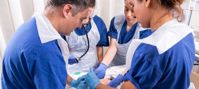 A group of people on an ARNI course, standing around a manikin