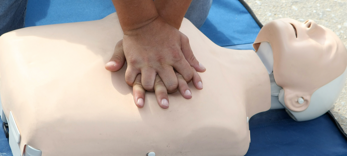 Person practices CPR on a training manikin