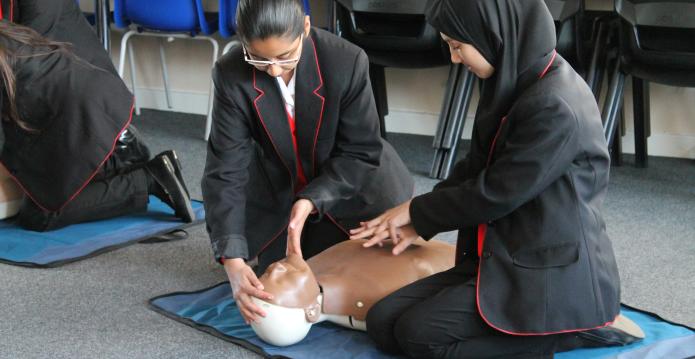 School children practicing CPR on mannikin 
