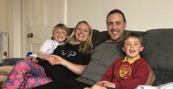 Richard Moore sitting on the couch with his family