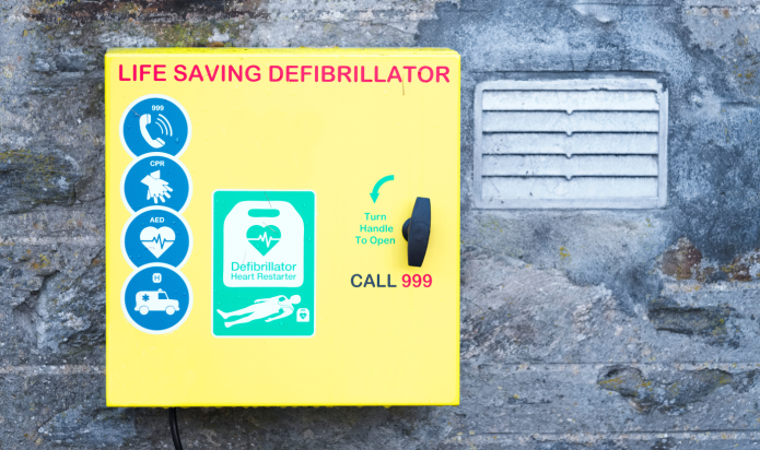 yellow public access defibrillator cabinet mounted on a wall