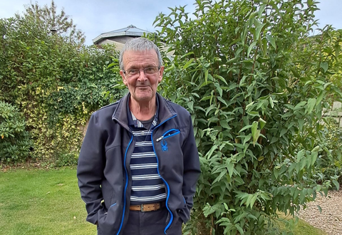 MacLean MacLeod smiling for a photo in a garden