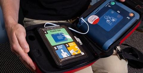 Person holding open an AED